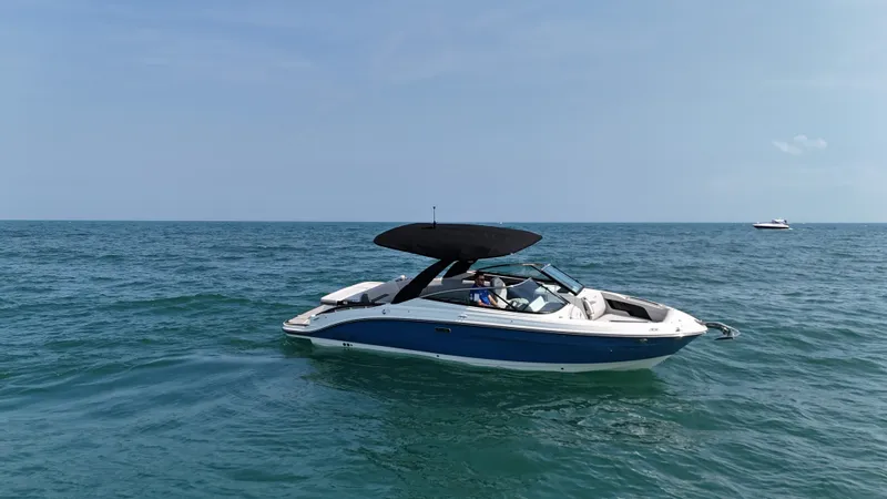 Slide: The Image of A 2027 Sea Ray SLX 280 cruising on calm waters. It features a blue and white design with a black sunshade. - 4