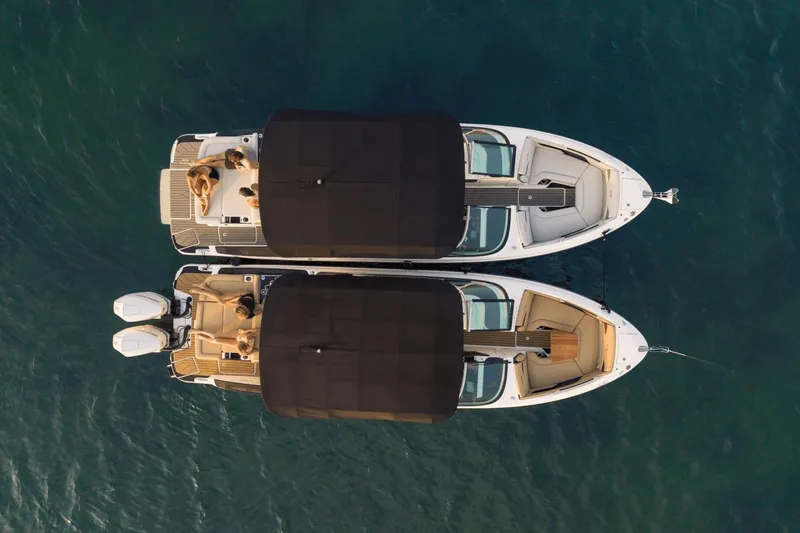 Slide: The Image of Two Sea Ray SLX 280 boats viewed from above, side by side on calm water, with black sunshades. - 44