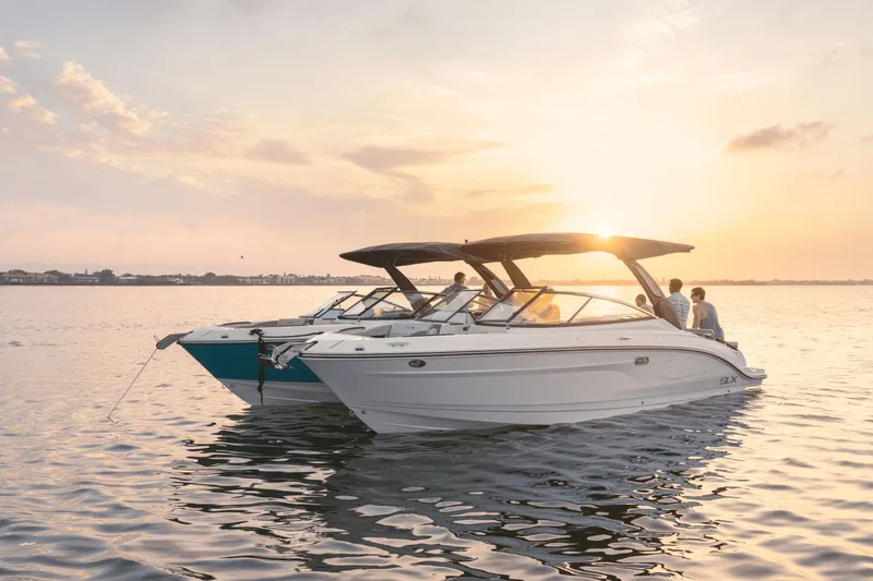 Slide: The Image of Two Sea Ray SLX 280 boats on calm water at sunset, with people on board. - 45