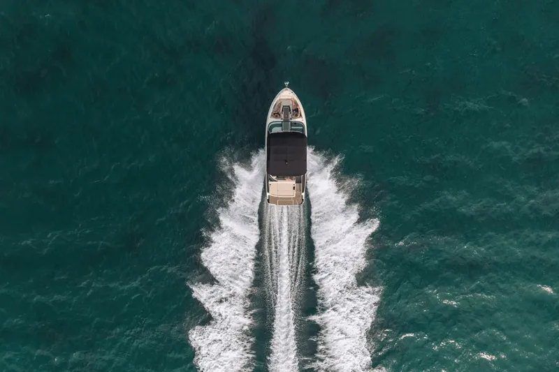 Slide: The Image of Aerial view of a Sea Ray SLX 280 boat cruising through turquoise water, leaving a white wake. - 43