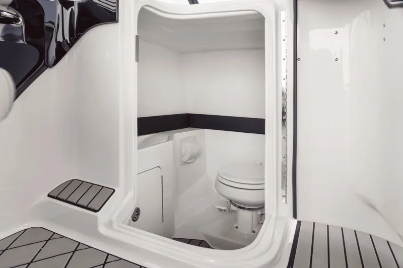 Slide: The Image of The cabin of a 2027 Sea Ray SLX 280 features a clean, modern toilet with white walls. - 8