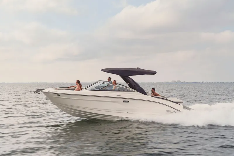 Slide: The Image of A 2027 Sea Ray SLX 280 speeds across the water, with several people on board. - 2
