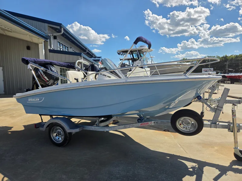 Slide: The Image of A blue 2027 Boston Whaler 130 Super Sport on a trailer in front of a building. - 2