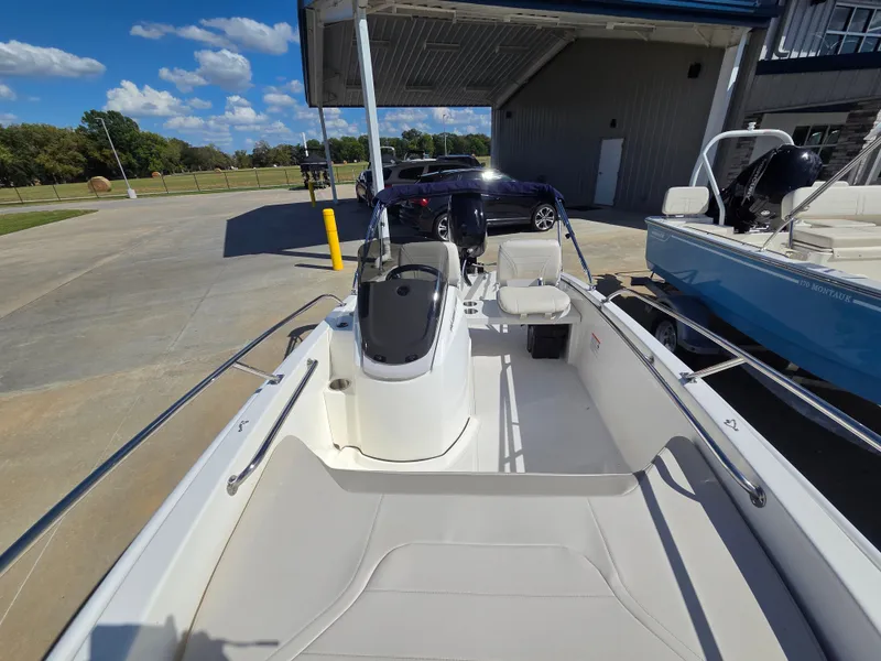 Slide: The Image of The image shows a 2027 Boston Whaler 130 Super Sport boat in a dockside area. - 6
