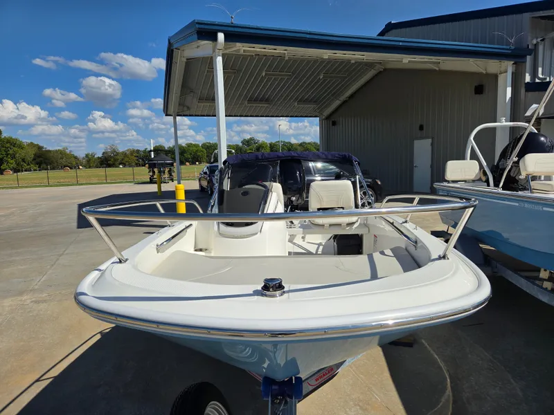 Slide: The Image of Boston Whaler 130 Super Sport 2027 in front of a building with a blue roof. - 3