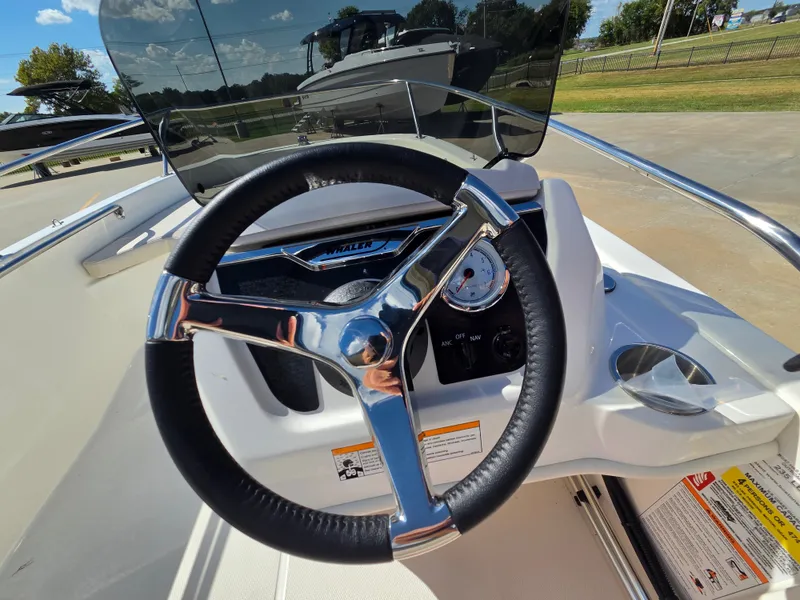 Slide: The Image of The image shows the helm of a 2027 Boston Whaler 130 Super Sport with a shiny steering wheel. - 8