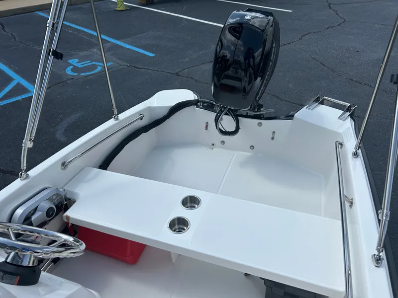 Slide: The Image of The image shows the cockpit of a 2027 Boston Whaler 130 Super Sport. It features a white bench seat and an outboard motor. - 15