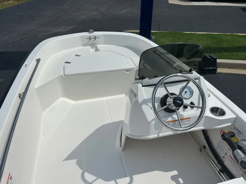 Slide: The Image of The image shows the cockpit of a 2027 Boston Whaler 130 Super Sport with steering wheel and windshield. - 6