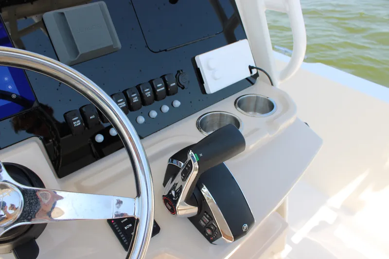 Slide: The Image of The image shows the helm of a Boston Whaler 250 Dauntless with modern controls and cup holders. - 26