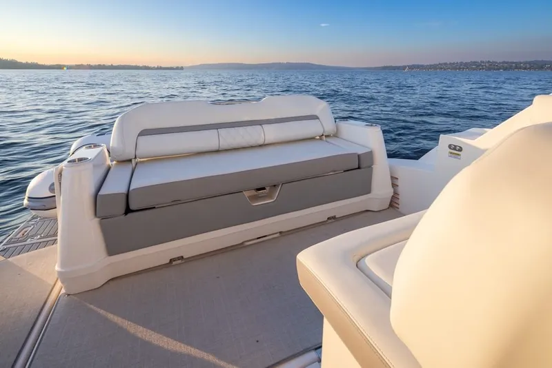Slide: The Image of 2024 Regal 36 Grande Coupe boat interior with luxurious seating, overlooking serene waters at sunset. - 17