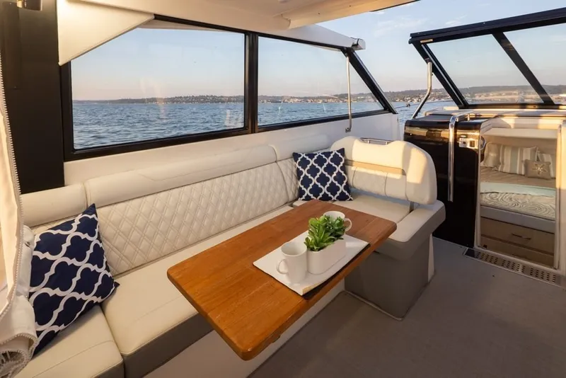 Slide: The Image of Luxurious interior of 2024 Regal 36 Grande Coupe yacht with elegant seating and scenic ocean view. - 4