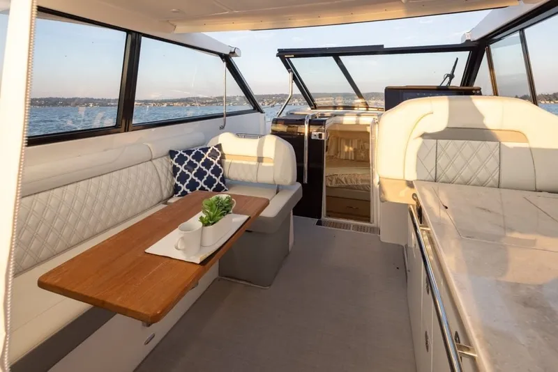 Slide: The Image of 2024 Regal 36 Grande Coupe interior with elegant seating and scenic water view. - 3