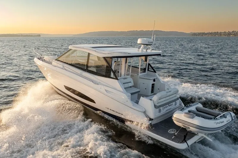 Slide: The Image of 2024 Regal 36 Grande Coupe cruising on open water at sunset. - 22