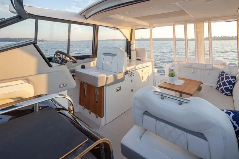 Slide: The Image of 2024 Regal 36 Grande Coupe interior with luxurious seating and scenic ocean view. - 15
