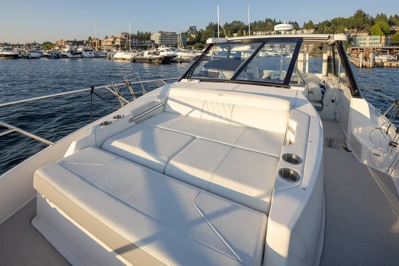 Slide: The Image of 2024 Regal 36 Grande Coupe luxury yacht with spacious sun deck on a scenic waterfront. - 19