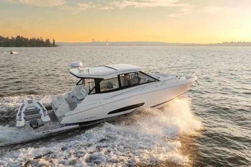 Slide: The Image of 2024 Regal 36 Grande Coupe cruising on a serene lake at sunset. - 24