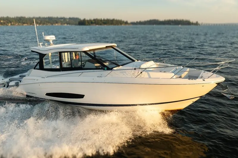 Slide: The Image of 2024 Regal 36 Grande Coupe cruising on open water at sunset. - 21