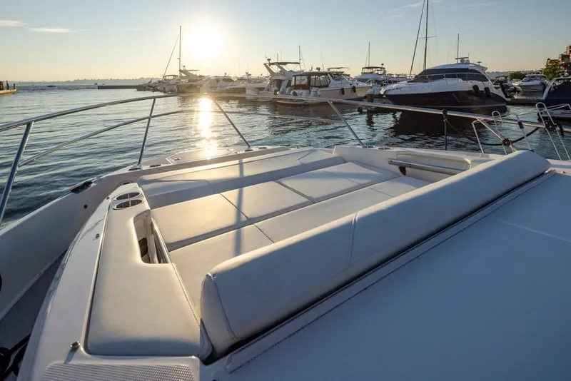 Slide: The Image of 2024 Regal 36 Grande Coupe yacht at sunset in marina, showcasing luxurious deck seating. - 20