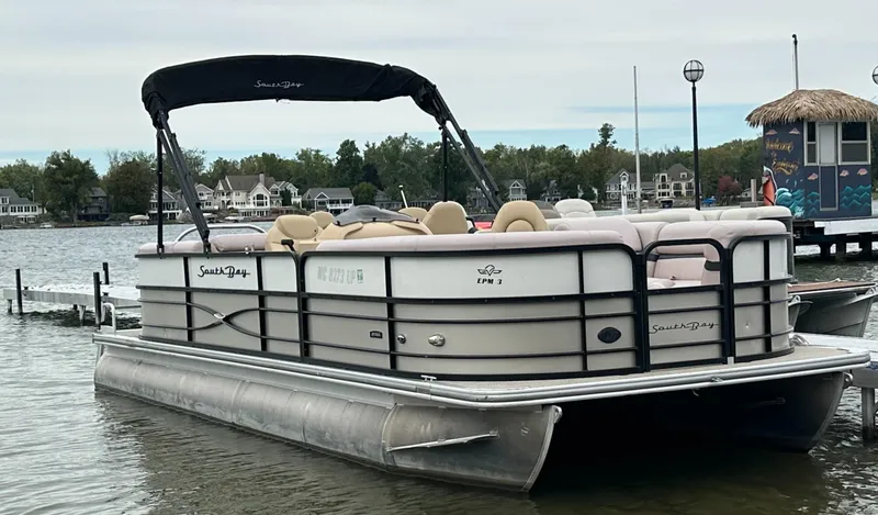 Slide: The Image of A 2019 South Bay pontoon boat docked on a calm lake. - 4