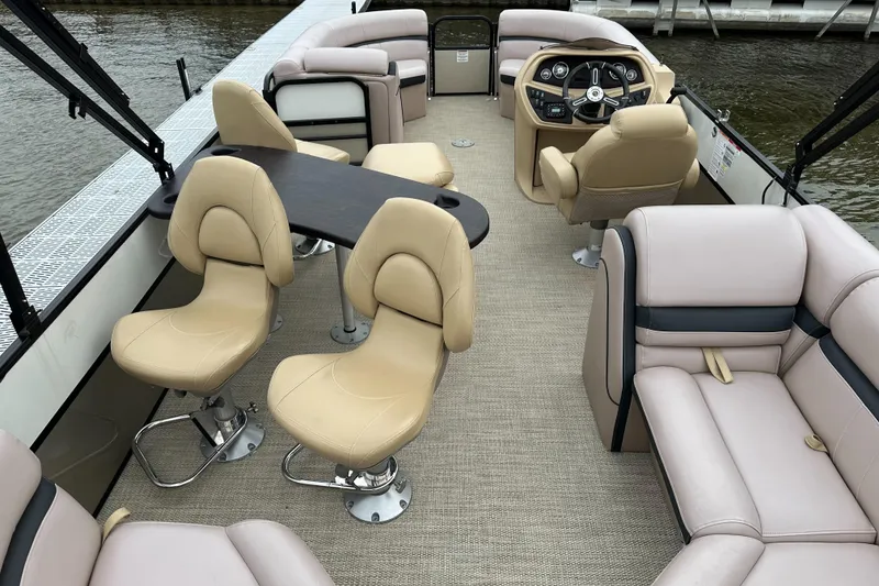 Slide: The Image of Interior of a 2019 South Bay S224SB225 pontoon boat with beige seating and table. - 12