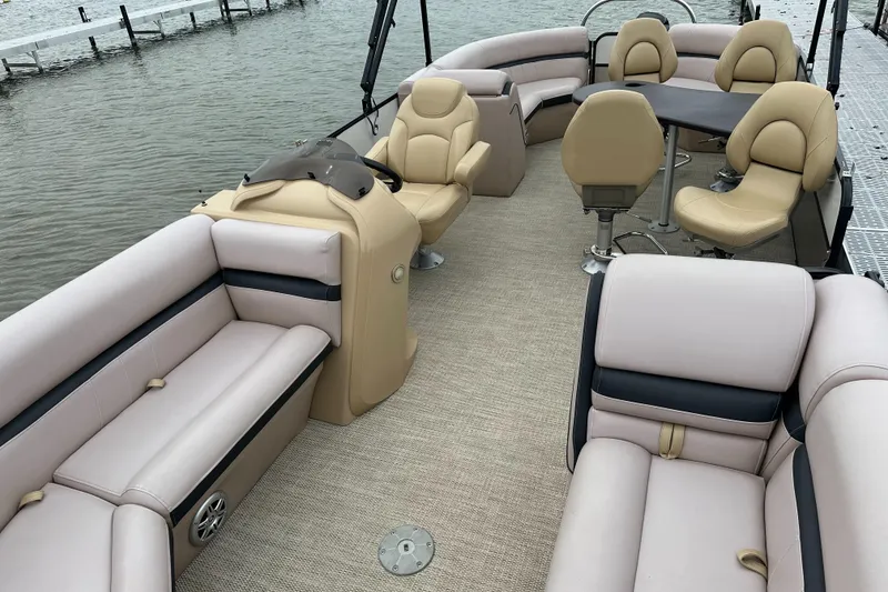 Slide: The Image of The image shows the interior of a South Bay pontoon boat with beige seating and a table. - 11