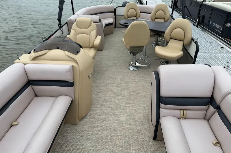 Slide: The Image of The image shows the interior of a South Bay pontoon boat with beige seating and a table. - 10