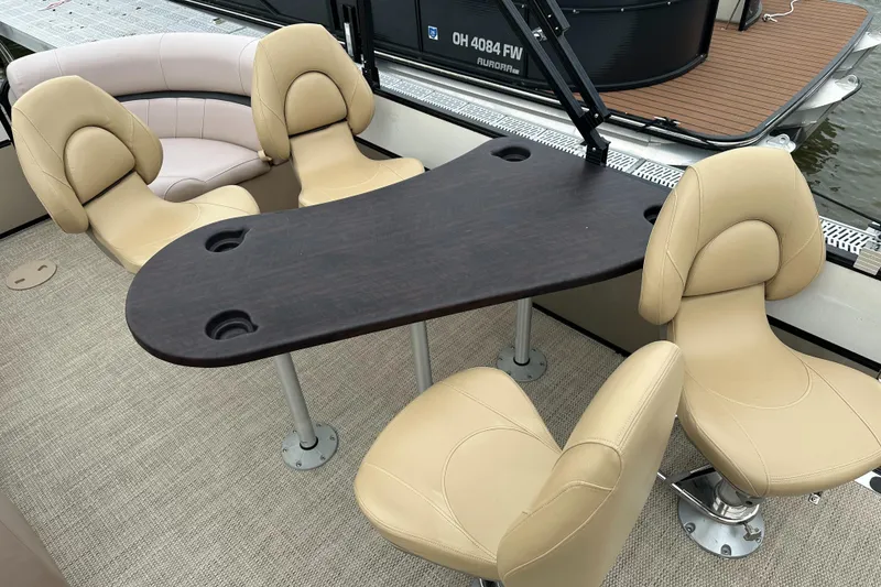Slide: The Image of A sleek table with four beige seats on a boat. - 13