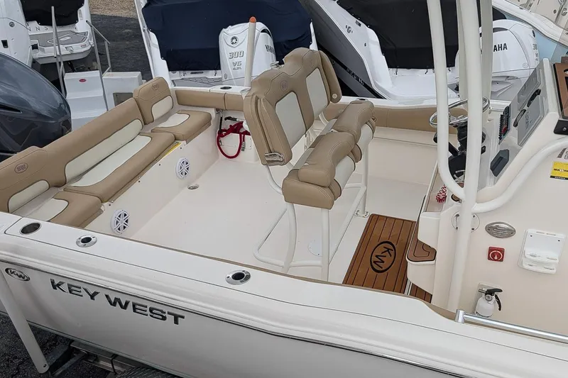 Slide: The Image of 2019 Key West 239 FS boat interior with beige seating and modern console. - 19