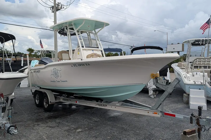 Slide: The Image of 2019 Key West 239 FS boat on trailer, parked outdoors under cloudy sky. - 1