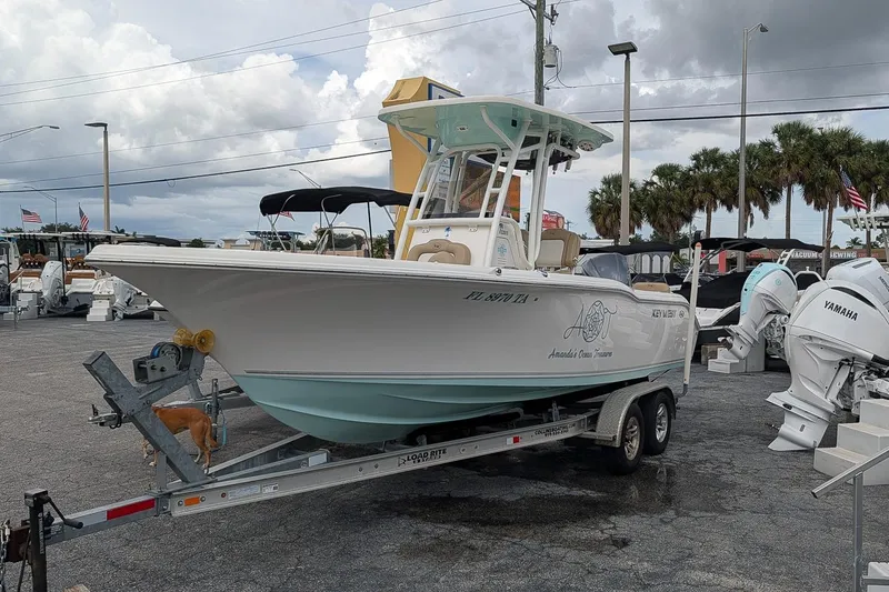Slide: The Image of 2019 Key West 239 FS boat on trailer in dealership lot, cloudy sky background. - 0