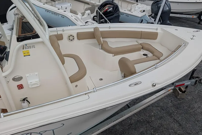 Slide: The Image of 2019 Key West 239 FS boat with beige seating and sleek design on a trailer. - 20