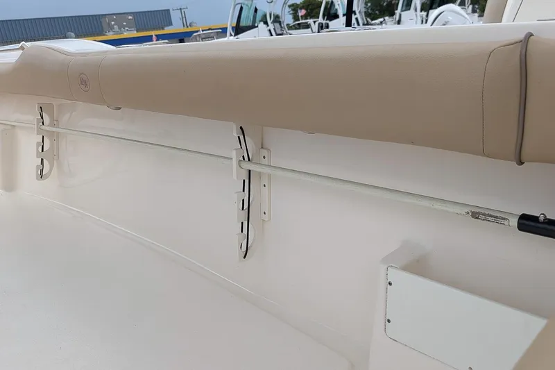 Slide: The Image of 2019 Key West 239 FS boat interior with beige cushioned seating and rod holder. - 14