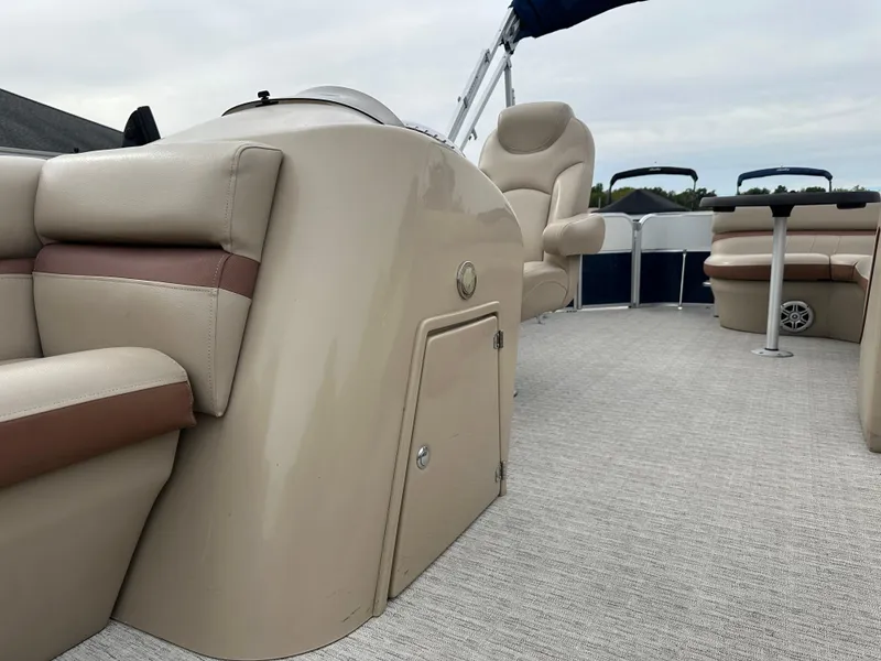 Slide: The Image of The image shows the interior of a 2018 South Bay S224CR pontoon boat with beige seating. - 7