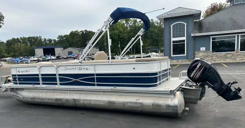 Slide: The Image of A 2018 South Bay S224CR pontoon boat is parked on a lot in front of a building. - 3