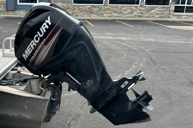 Slide: The Image of A Mercury outboard motor is attached to a boat parked in a lot. - 16