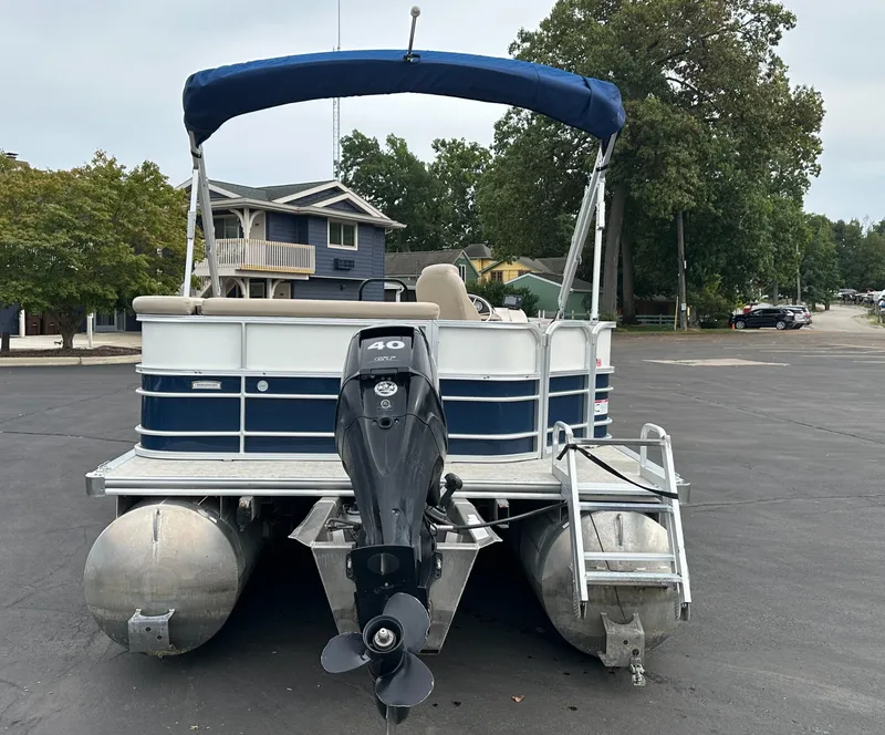 Slide: The Image of A 2018 South Bay S224CR pontoon boat with a blue canopy and outboard motor. - 18