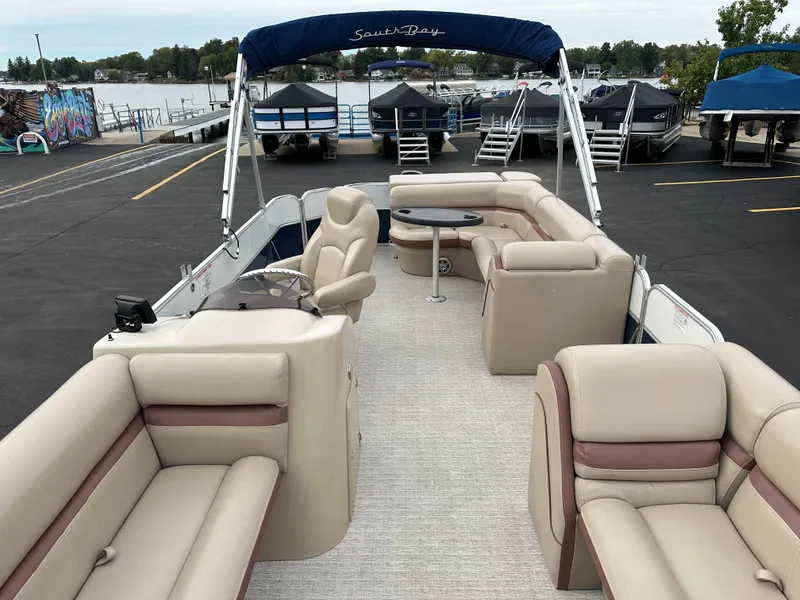 Slide: The Image of A 2018 South Bay S224CR pontoon boat with beige seating and a blue sunshade. - 5