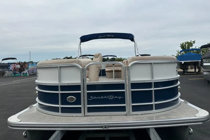 Slide: The Image of A 2018 South Bay S224CR pontoon boat on a trailer, featuring blue and white details. - 4