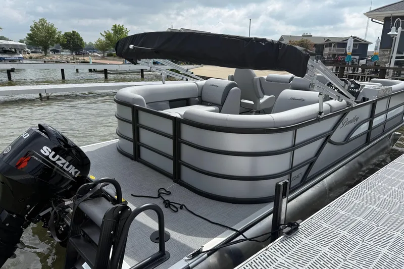 Slide: The Image of 2026 Bentley Pontoons Legacy 220 Navigator docked with Suzuki outboard motor. - 1