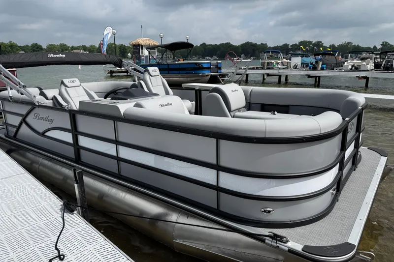 The Image of 2026 Bentley Pontoons Legacy 220 Navigator docked on a lake under cloudy skies. - 0