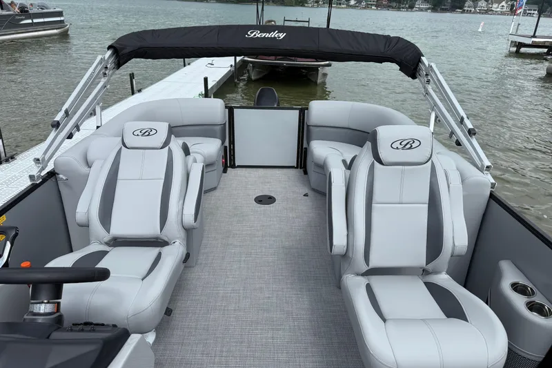 Slide: The Image of 2026 Bentley Pontoons Legacy 220 Navigator interior with luxurious seating on a lake. - 6