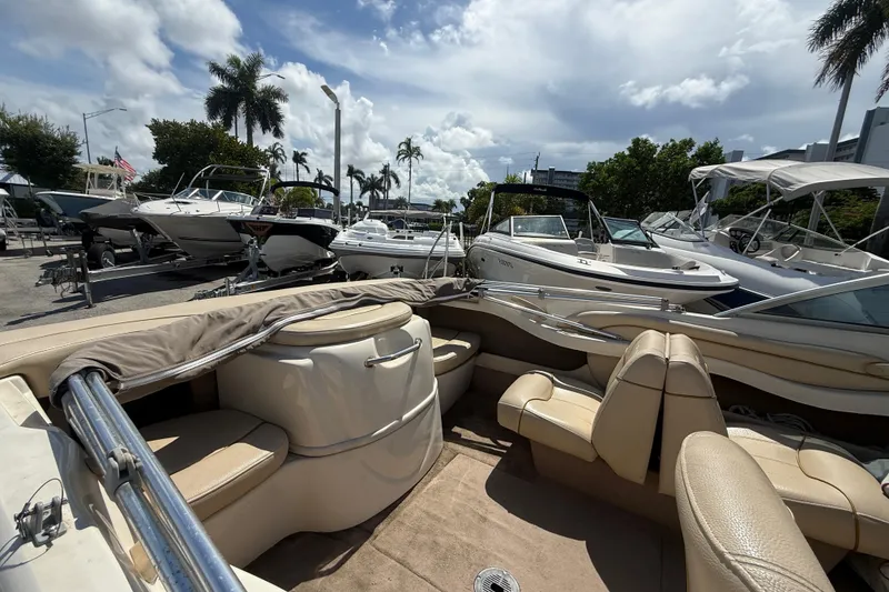 Slide: The Image of 2001 Sea Ray 180 Bow Rider boat in a marina, surrounded by other boats under a cloudy sky. - 6