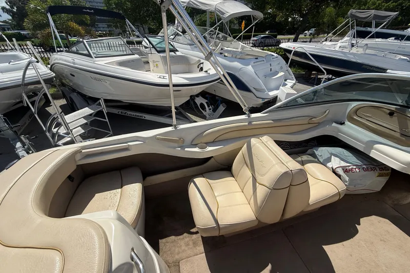 Slide: The Image of 2001 Sea Ray 180 Bow Rider boat with beige interior, parked among other boats. - 10