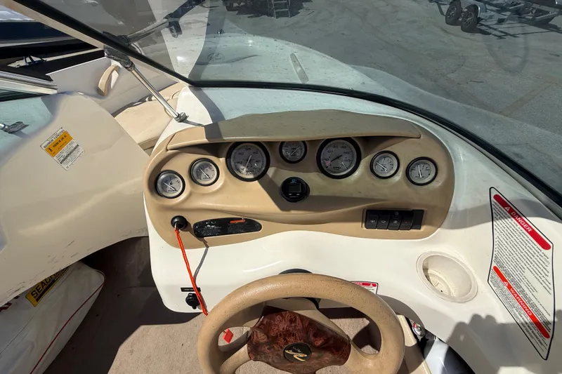 Slide: The Image of Dashboard of a 2001 Sea Ray 180 Bow Rider boat with gauges and steering wheel. - 12