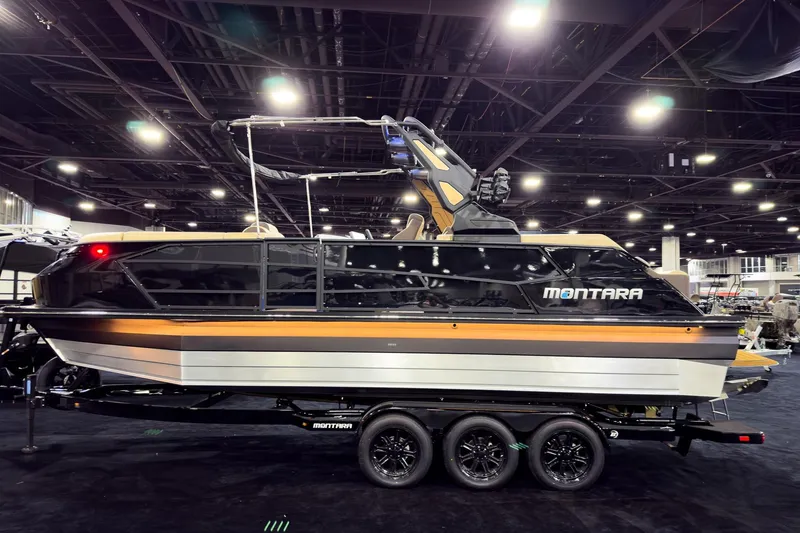 Slide: The Image of 2026 Montara Surf Boss EVO SLDH 25' boat displayed indoors on a trailer. - 1