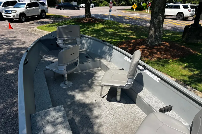 Slide: The Image of 2012 Alumacraft Fisherman 160 Tiller boat with seating, parked outdoors. - 2