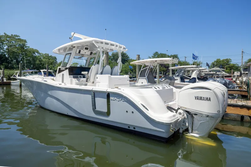 The Image of A white Sea Fox 328 Commander boat is on the water, surrounded by other boats. - 0