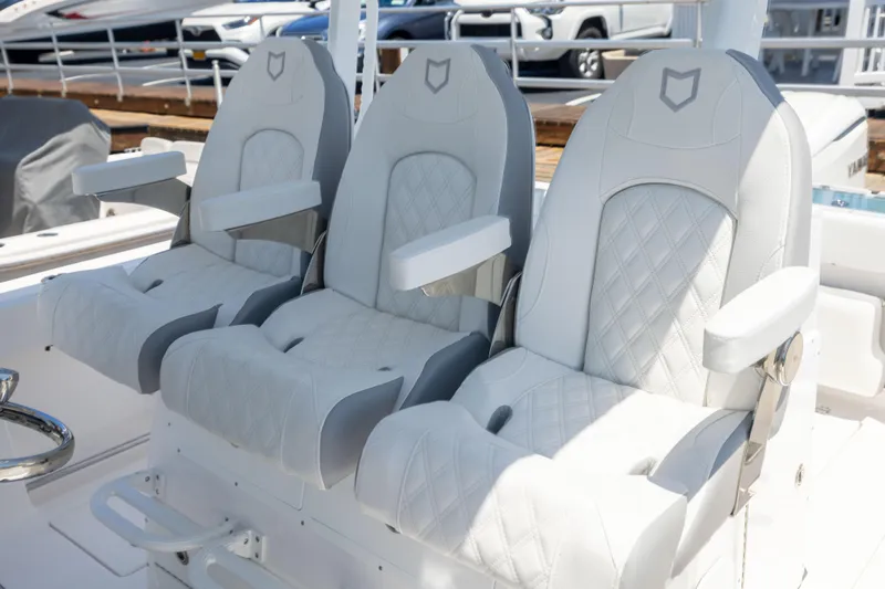Slide: The Image of Three luxurious, padded boat seats with armrests and quilted design on a deck. - 29