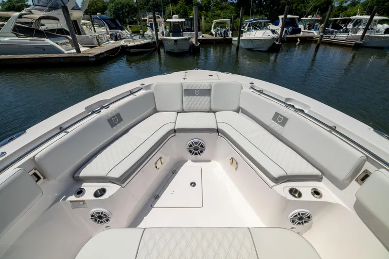 Slide: The Image of The image shows the bow area of a Sea Fox 328 Commander with cushioned seating and speakers. - 48
