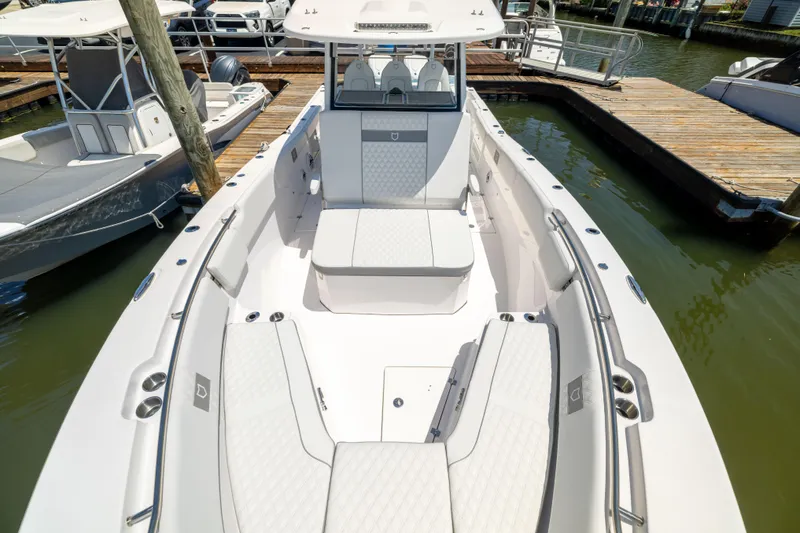 Slide: The Image of A sleek boat with white upholstery docked at a marina. - 49
